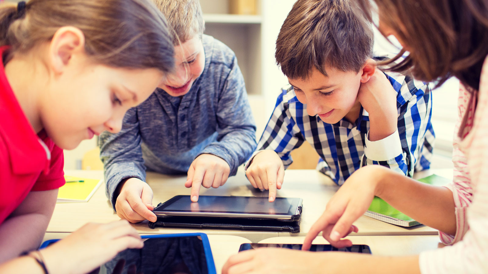 Børn sidder og arbejder sammen på iPads