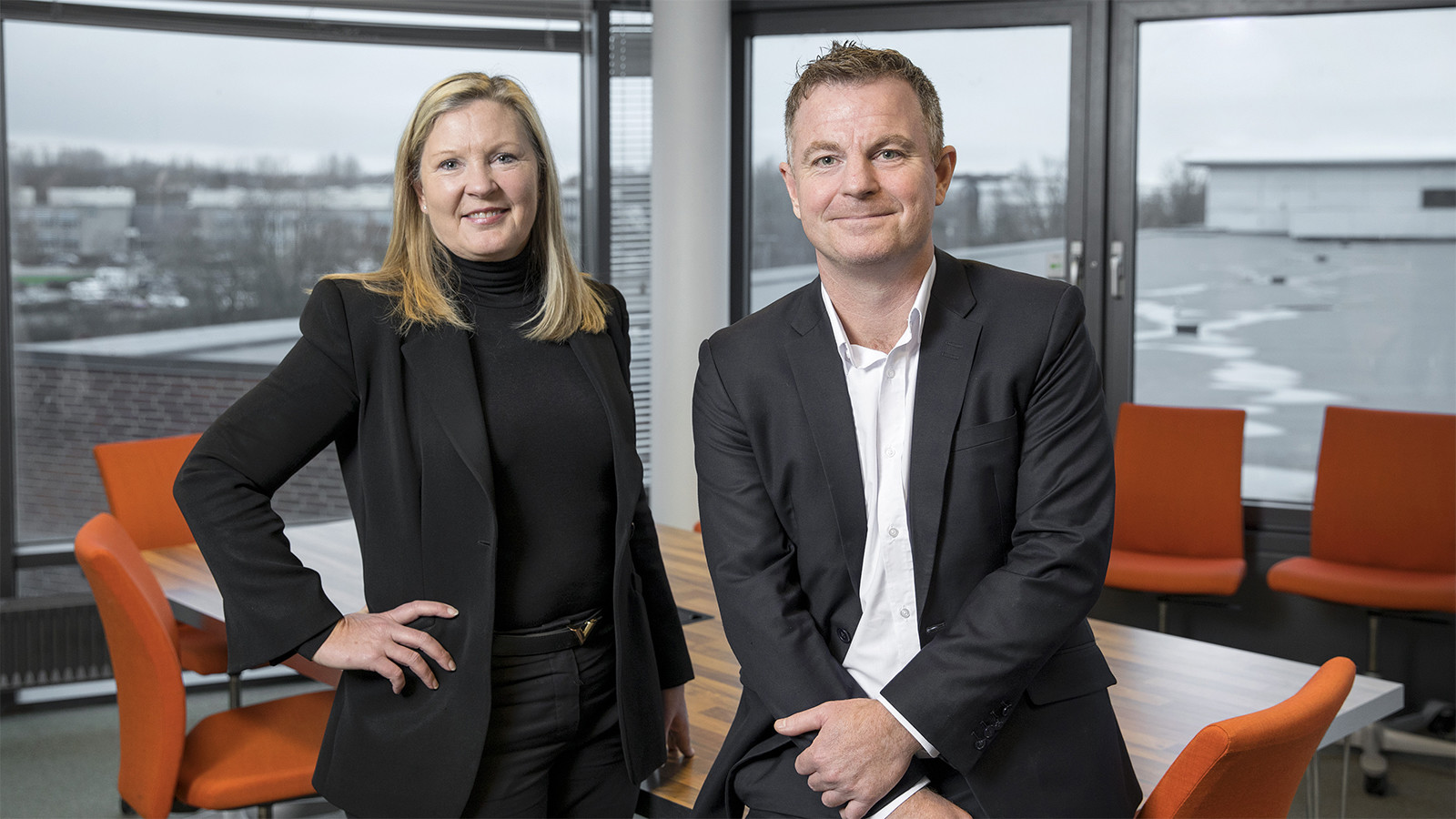 Torben Mols, KMD (til højre) og Kathrine Forsberg, administrerende direktør i Atea (til venstre) i et mødelokale med orange stole