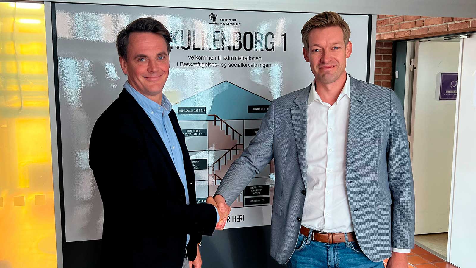 Fra venstre: Niels Brasch Bækholm, der er salgsansvarlig for beskæftigelsesområdet i KMD, bekræfter aftalen sammen med Gorm Hjelm Andersen, Koncernchef i Odense kommune.
